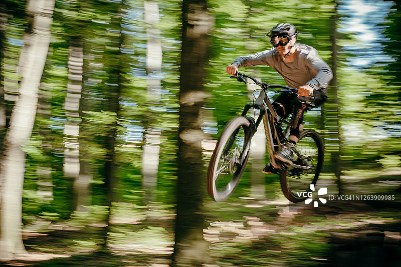 在森林里骑山地车的男人。骑自行车的人。图片素材