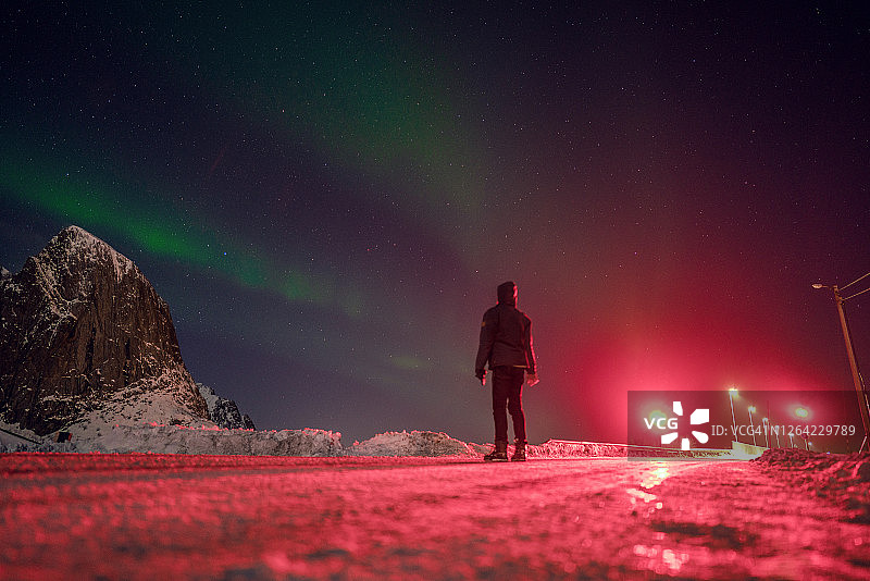 冬天，人们在路上观看罗浮敦群岛上的北极光图片素材