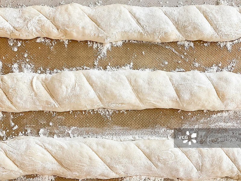 新鲜的自制面团在烘烤前卷成长棍面包图片素材
