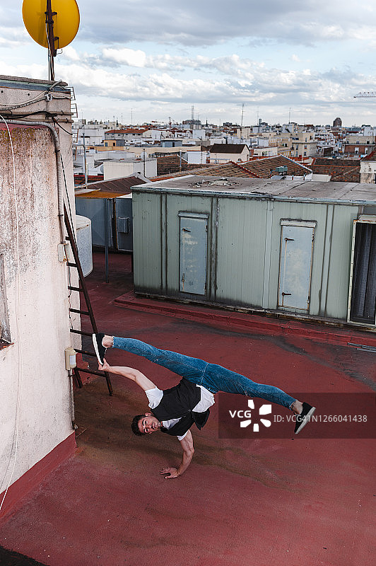 一个年轻人在城市的建筑露台上跳霹雳舞图片素材