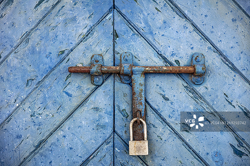 带挂锁的旧蓝色金属门图片素材