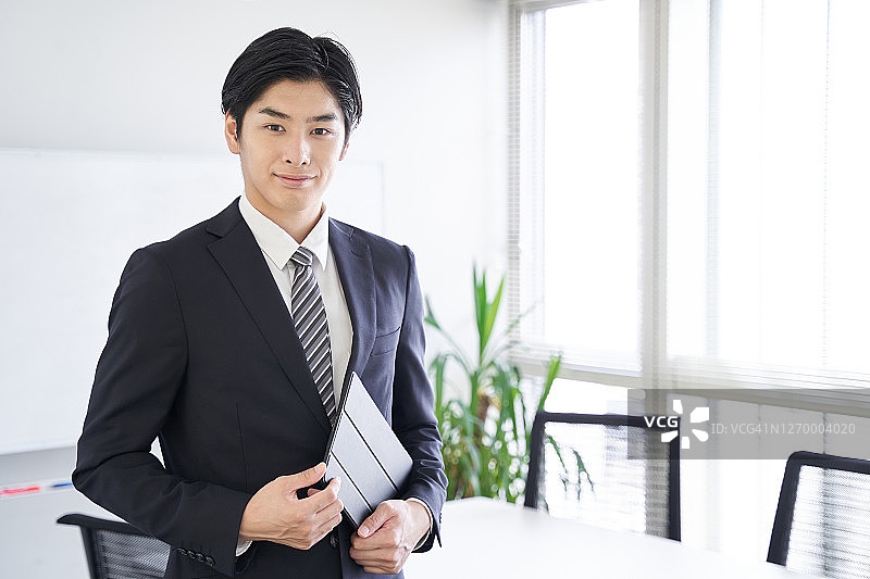 一名日本男性商人在会议室里拿着平板电脑图片素材