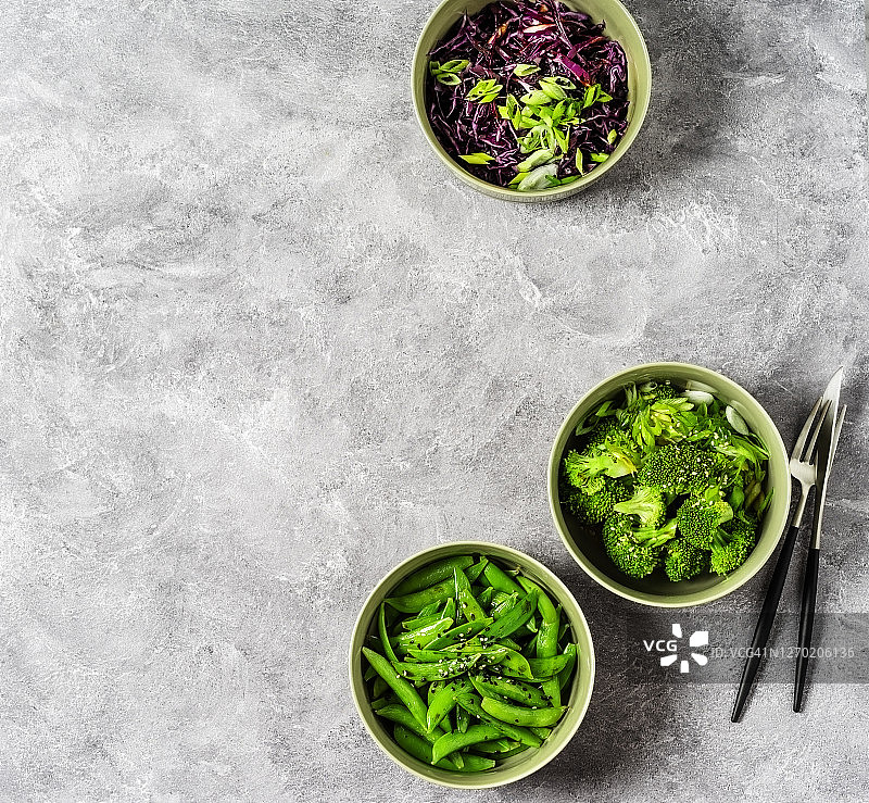 灰色背景上的沙拉碗(红卷心菜、花椰菜和糖豌豆)图片素材