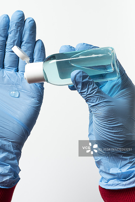 戴着医用手套的女医生把酒精消毒剂和防腐剂放在手上，从管子里挤出来。图片素材