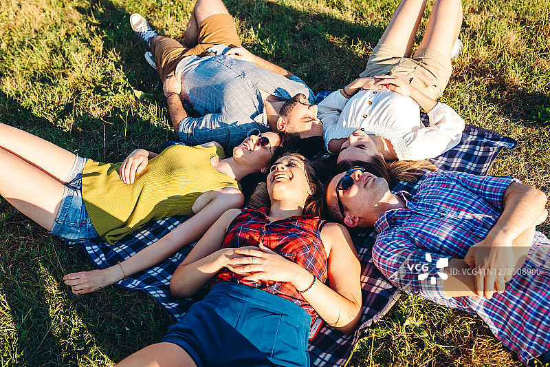 幸福的朋友躺在草地上图片素材