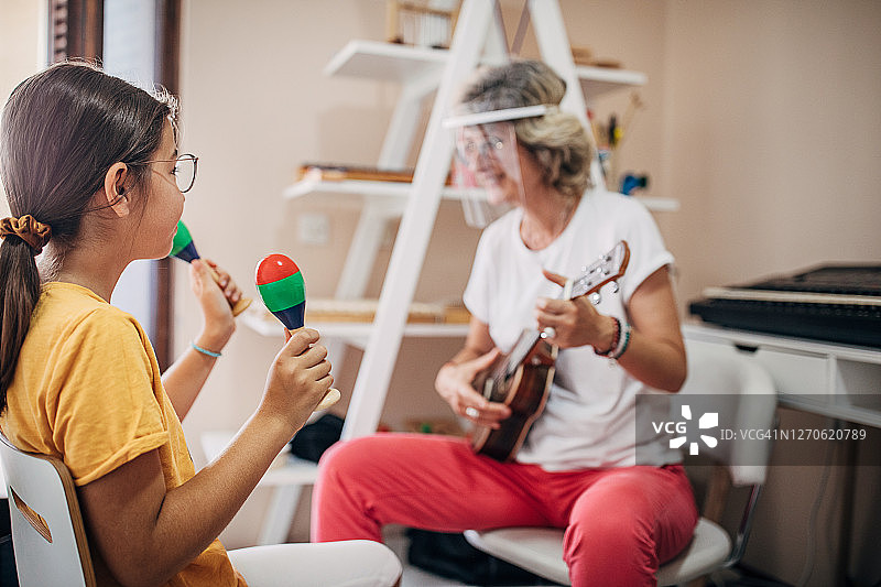 女孩和她的音乐老师在儿童发展中心玩耍图片素材