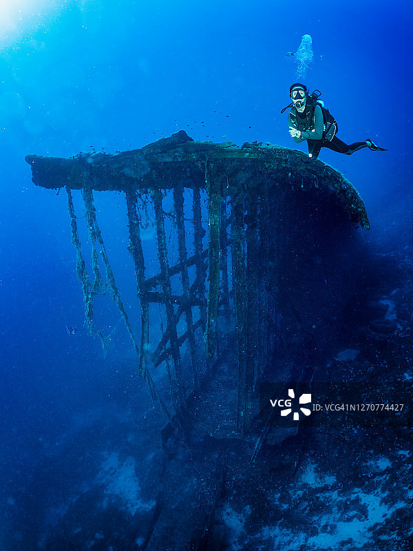 一名潜水员在一艘沉船前潜水图片素材