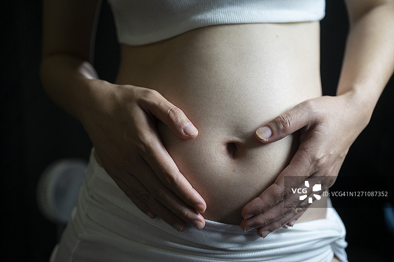 美丽的特写孕妇的触摸腹部和等待新生命的诞生图片素材