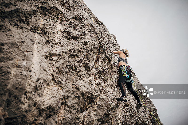 女子极限攀登者在爬山图片素材