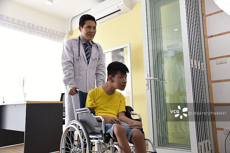 医生照顾一个坐在轮椅上的残疾男孩图片素材