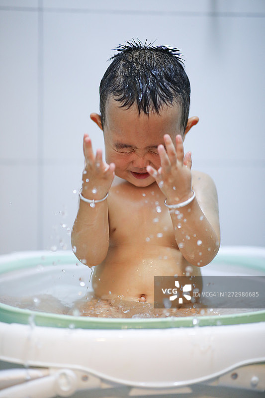 宝宝在洗澡时自己洗脸图片素材