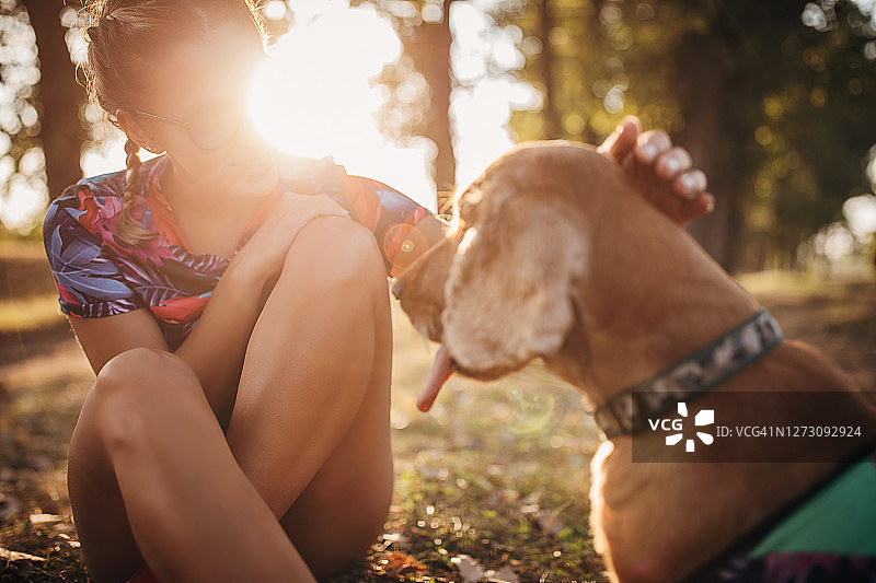 一个年轻女子抱着她的可卡犬在大自然中图片素材