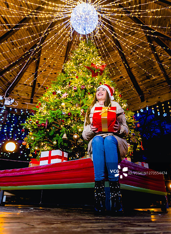 一个女人坐在圣诞树前图片素材