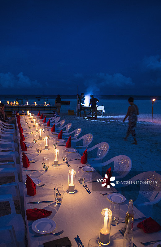 马尔代夫海岸海滩上的餐桌上燃烧着蜡烛图片素材