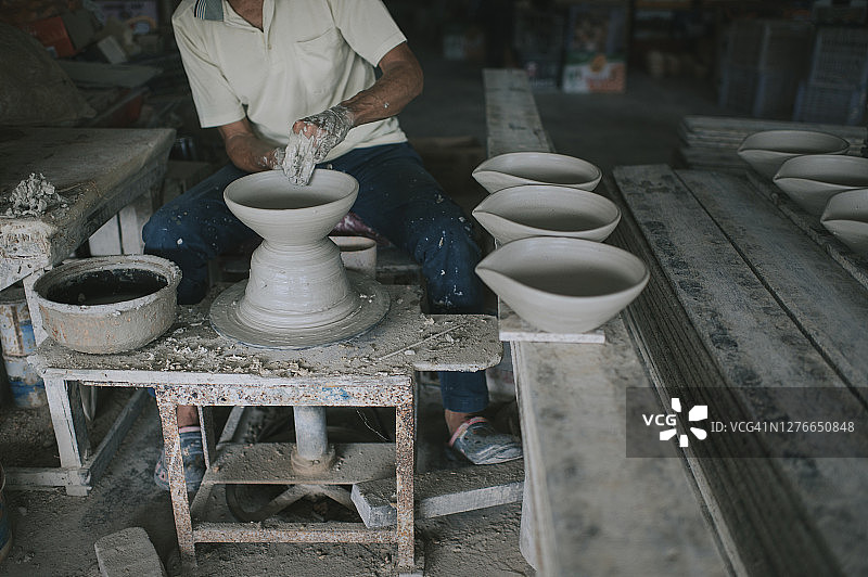 亚洲华人活跃的高级男子波特在他的工作室与纺织陶瓷轮工作图片素材