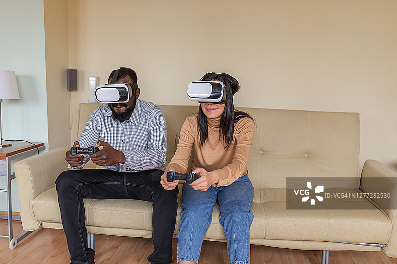 年轻的亚洲女人正在玩她的男朋友，而使用虚拟现实模拟器。图片素材