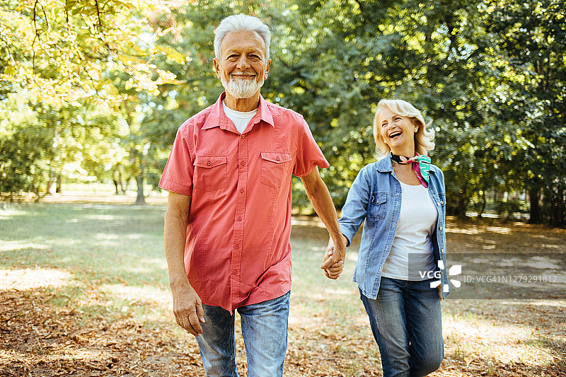 一对快乐的老夫妇在公园散步图片素材