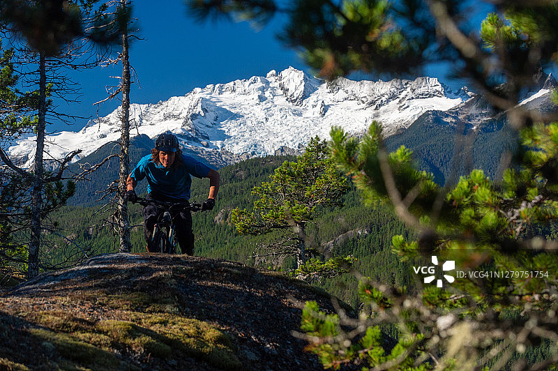 山地摩托车手在森林里骑过一块石板图片素材