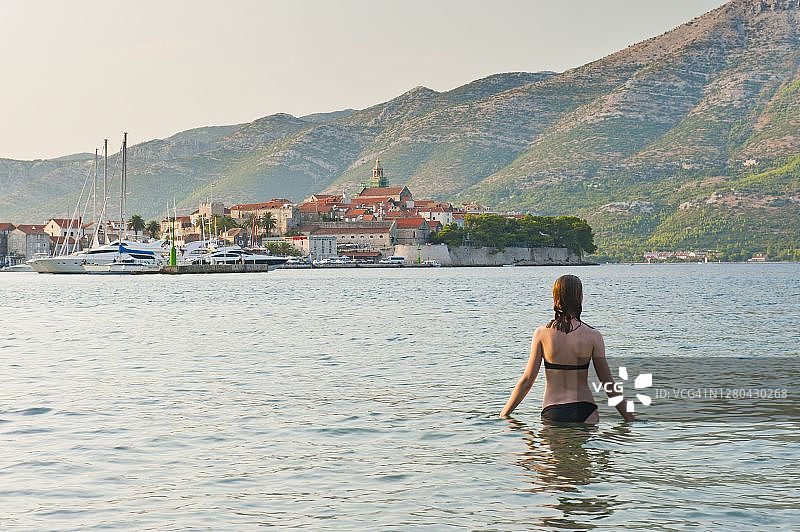 克罗地亚达尔马提亚，科尔库拉岛，科尔库拉镇港，女游客在游泳图片素材
