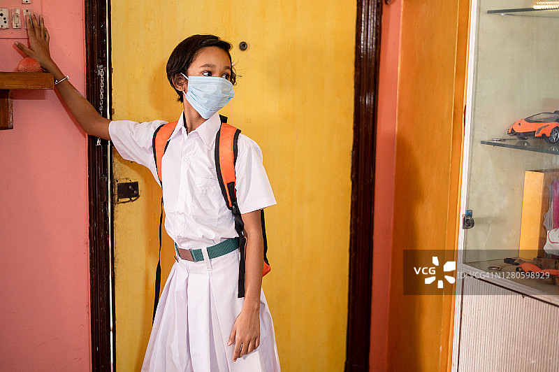 印度女学生戴着口罩上学以预防COVID-19。图片素材