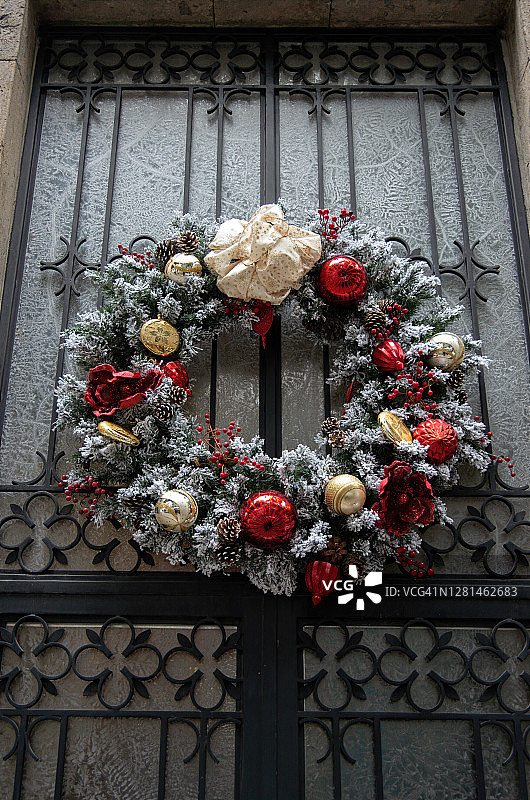 豪华的圣诞花环在优雅的锻铁和磨砂玻璃前门图片素材
