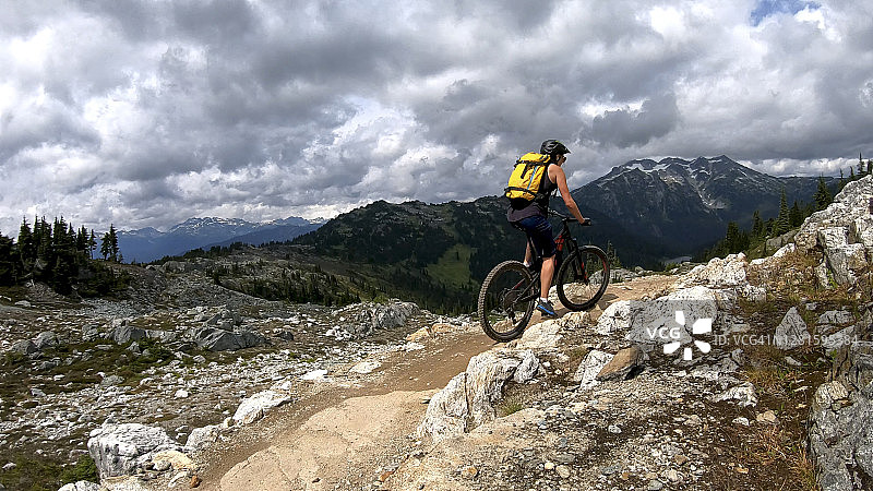 女性山地自行车骑上高山小径图片素材