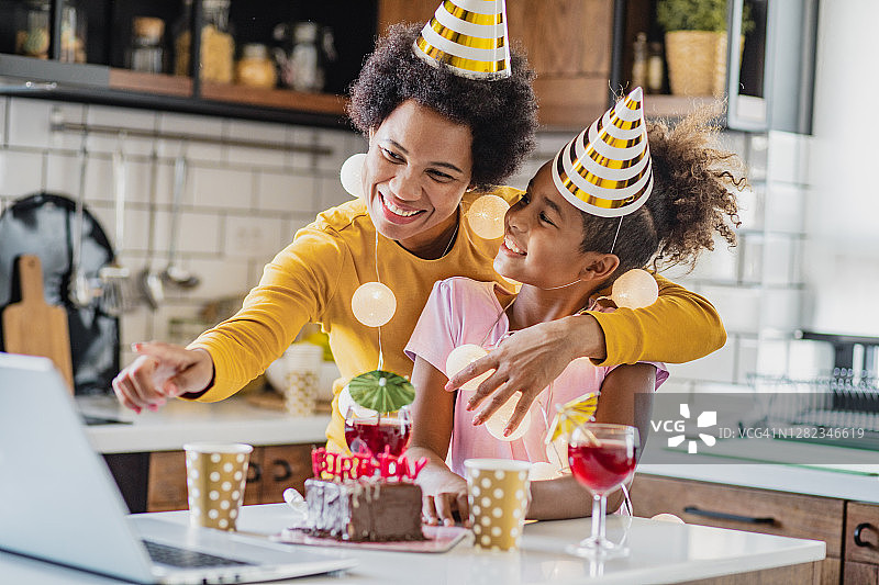 母亲和女儿在家网上庆祝生日图片素材