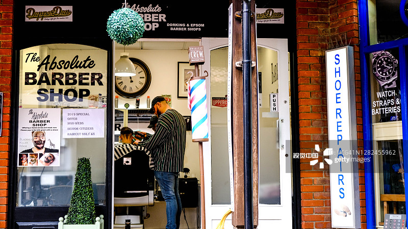 一名男子在一家传统的高街理发店里理发图片素材