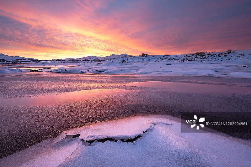 在挪威的一个极其丰富多彩的日出期间，冰雪覆盖的景观图片素材