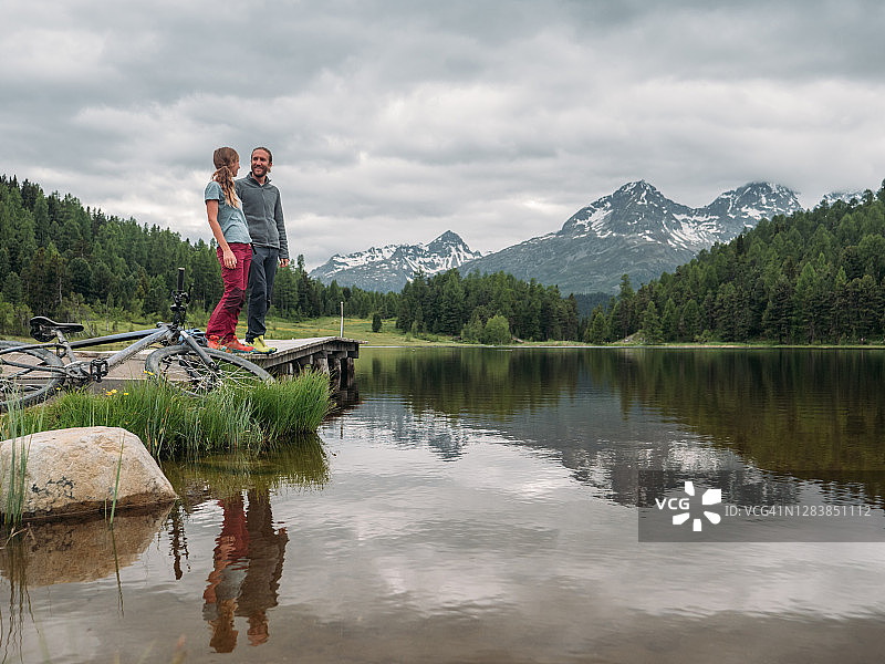 两个山地自行车手在湖边放松图片素材