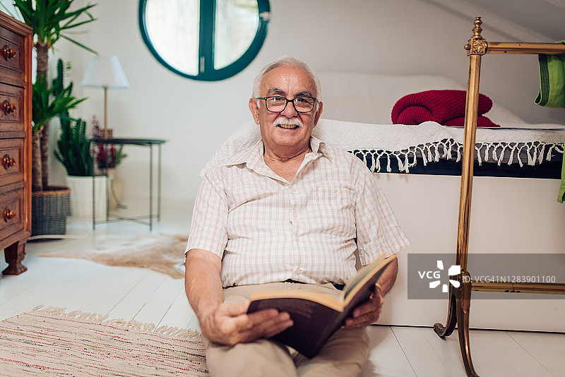 一个老人在家里享受阅读的肖像图片素材