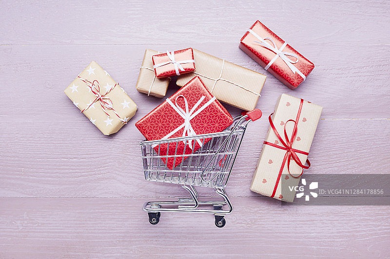 高角度的小购物车和礼物上的紫色木桌，网上购物图片素材