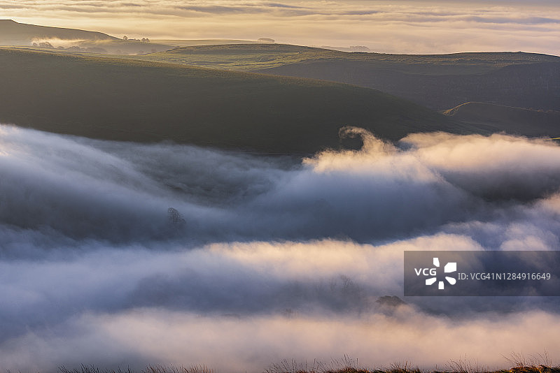 日出，德比郡山谷，皮克区，雾层。英国图片素材