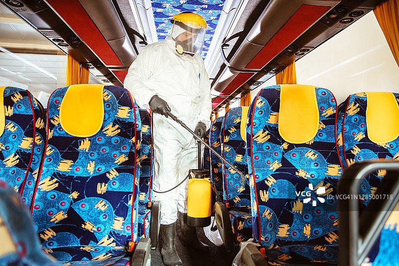 男性穿着白色化学防护服做消毒图片素材