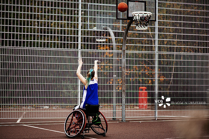 坐在轮椅上的少年在打篮球，在罚球线上投篮图片素材
