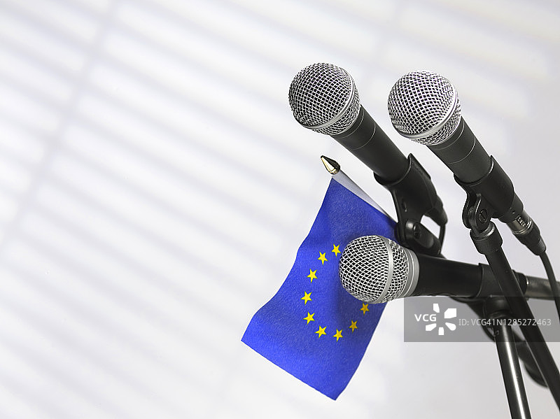 新闻发布会的麦克风上挂着欧盟旗帜图片素材