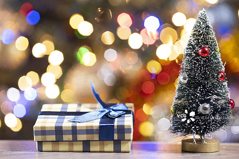 近距离的圣诞礼物旁边装饰的圣诞树。一串圣诞彩灯作为背景图片素材
