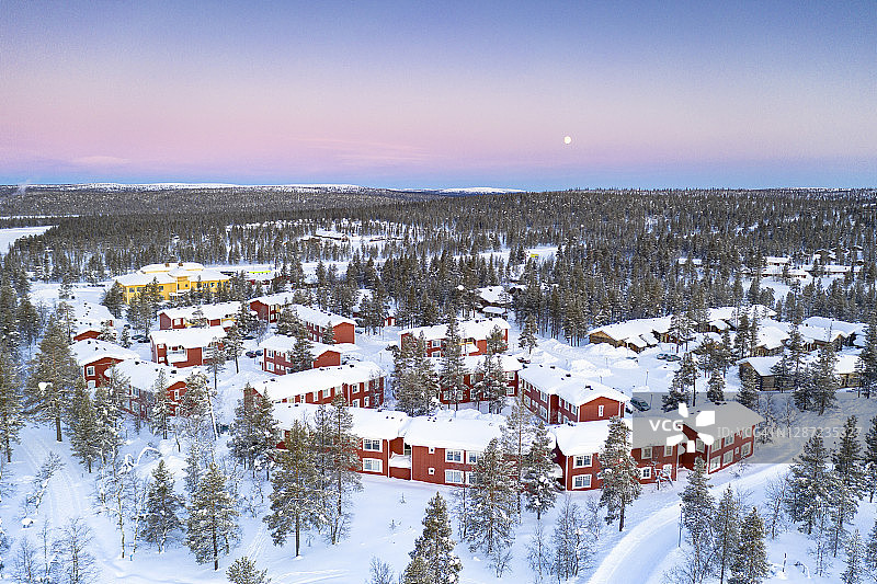 北极日出在雪域森林和旅游度假小屋，拉普兰图片素材