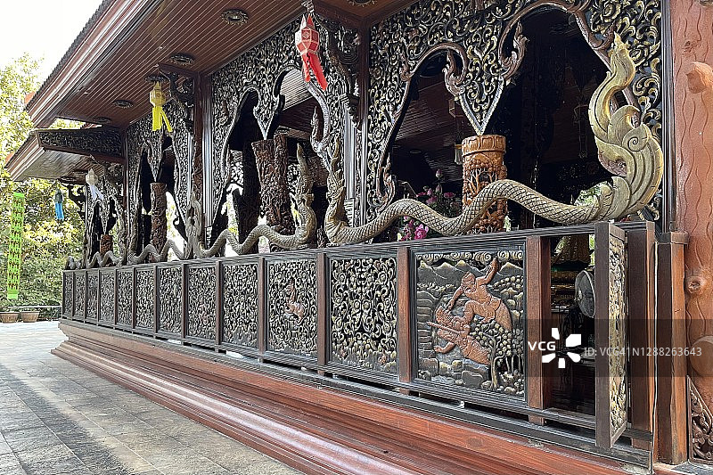 Pong Nam Ron旅游目的地- Wat Khao Chawang Temple的木制教堂(外部)有漂亮的木材渴望，大理石佛像和花卉装饰。图片素材