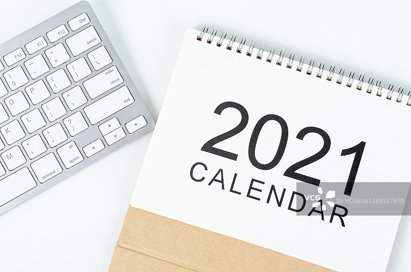 日历书桌2021为组织者规划和提醒和白色电脑键盘电脑在木制桌子上。图片素材