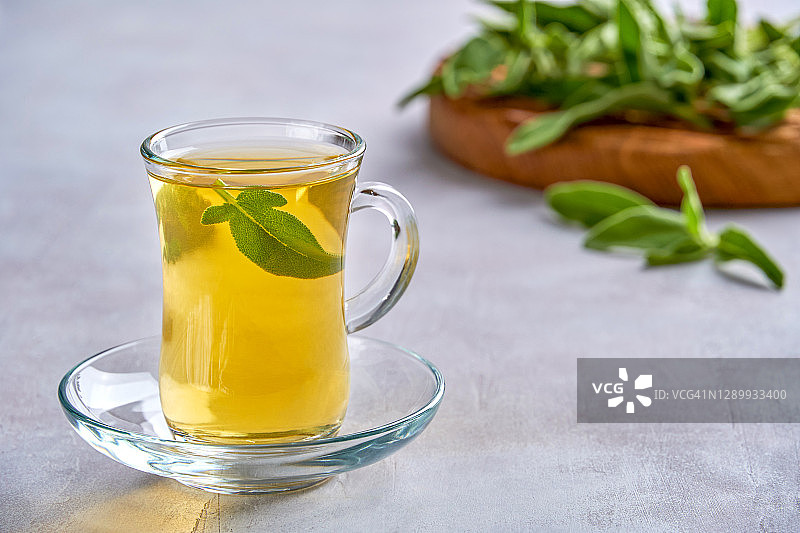 一杯热鼠尾草茶，用新鲜的叶子，健康的理念，拉近图片素材