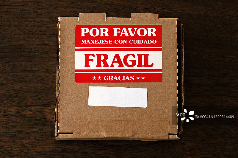 西班牙语纸箱包裹易碎:贴上小心标签轻放图片素材