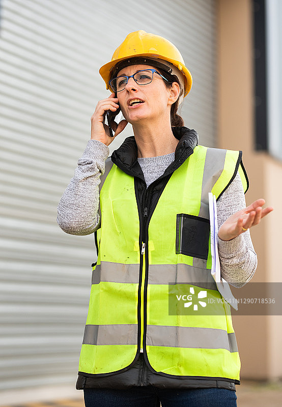 女工程师站在仓库外打电话图片素材