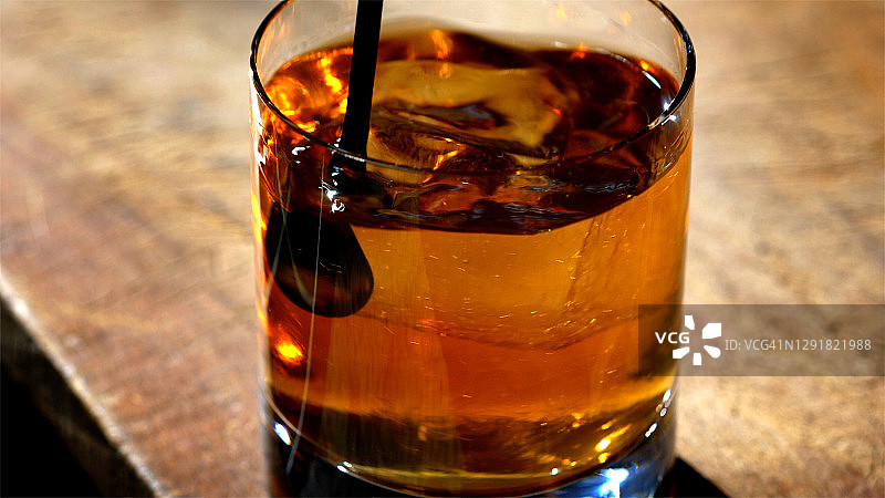 经典禁酒令曼哈顿鸡尾酒在老式岩石玻璃被搅拌图片素材