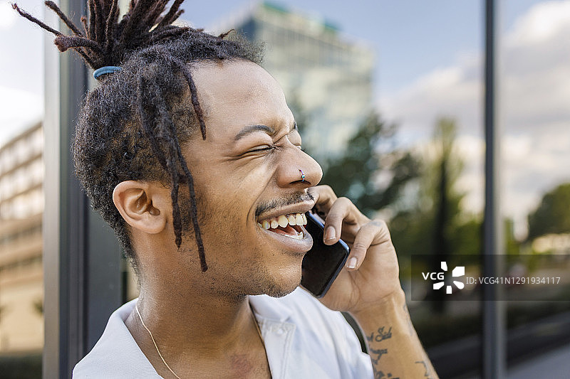 一个站在户外玩手机的快乐男人图片素材