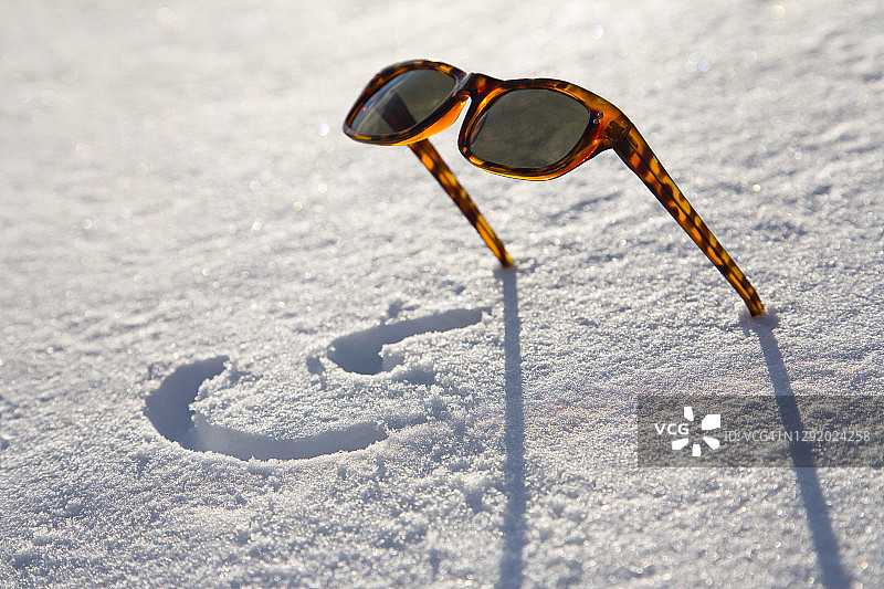 落在雪地里的太阳镜图片素材