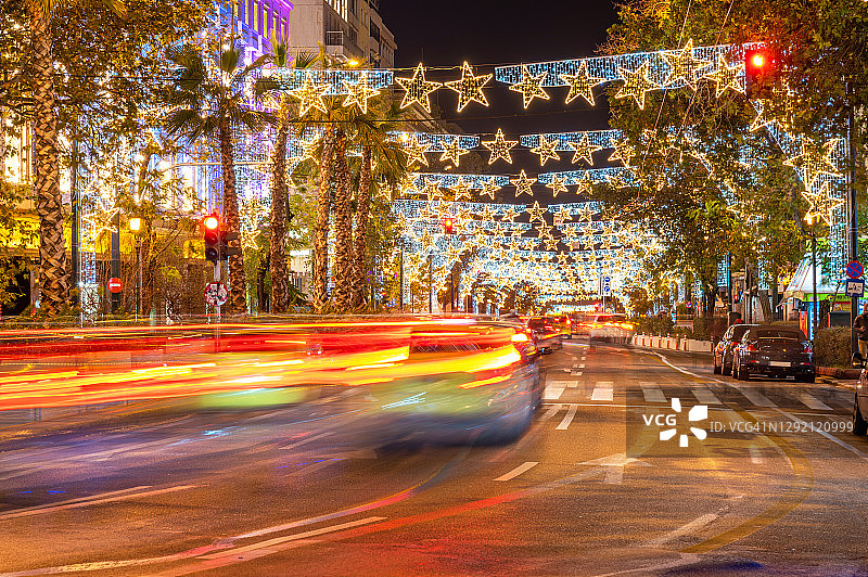 长时间暴露在装饰着圣诞彩灯的城市街道上图片素材