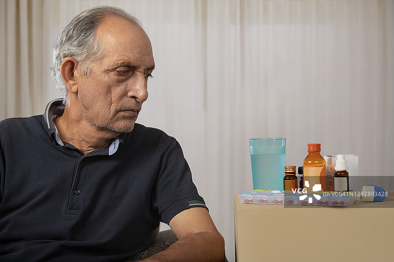 一位老人在看药物的肖像。(健康)图片素材