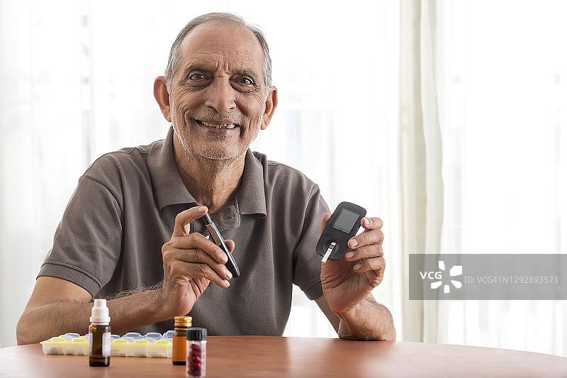 一个老人在家做糖尿病检查。(健康)图片素材