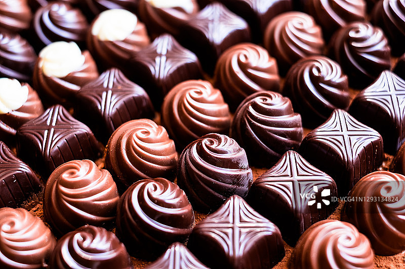 精选黑巧克力、牛奶巧克力和白巧克力糖果，选择性聚焦。巧克力的背景。宏食品摄影。糖果的集合。图片素材